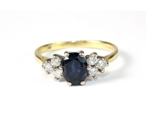 An 18ct yellow gold ring set with a sapphire and diamonds. Size N