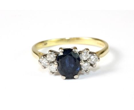 An 18ct yellow gold ring set with a sapphire and diamonds. Size N