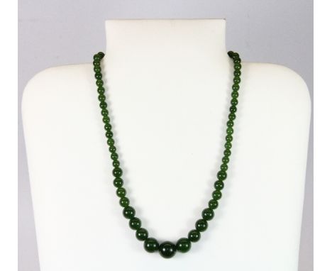 A graduated strand of spinach jade beads