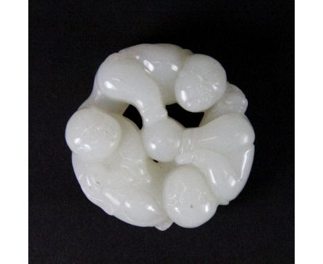 A Chinese carved white jade disc of 3 boys around a ball, Dia 5.5cm, Depth 2cm, (19th century)