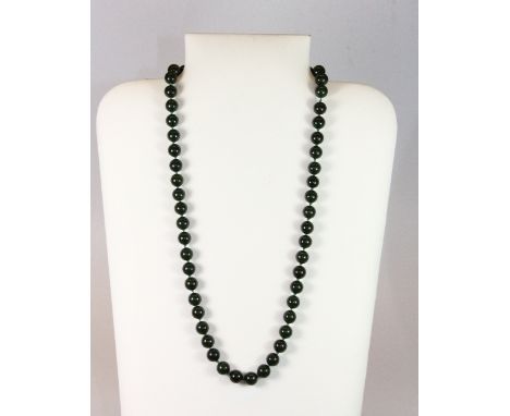 A single strand necklace of dark green jade beads.