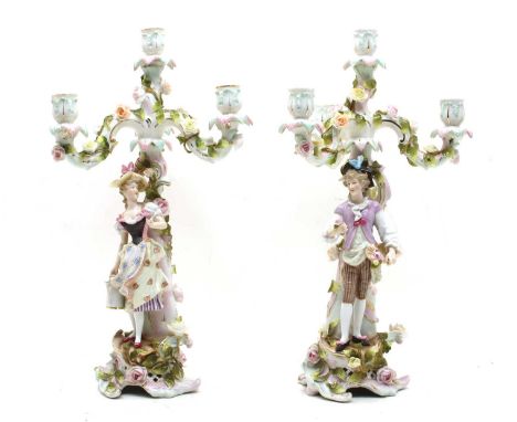 A pair of Sitzendorf floral encrusted four light table candelabra, each with a figure column, 42cm highCondition report: One 