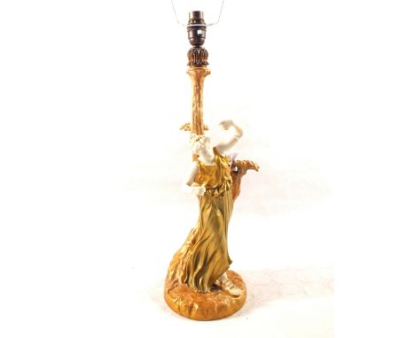 A Royal Worcester blush ivory table lamp in the form of a lady standing by a tree, Patt No. 1827