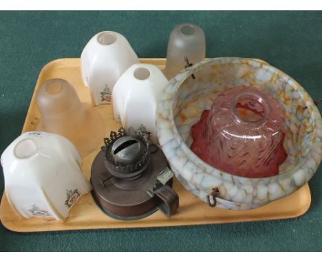 An oil lamp and various glass shades