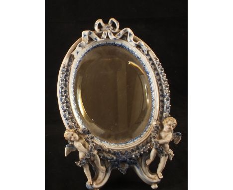 A Dresden blue and white easel mirror on twin cherub supports