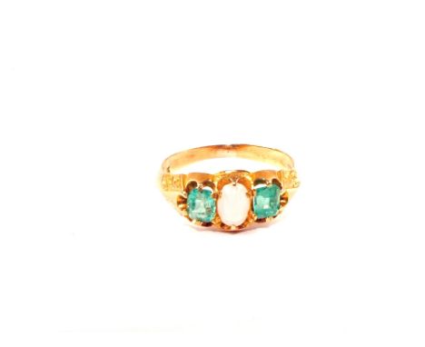 An 18ct Gold three stone ring set with two square cut Emeralds with Opal oval cut centre stone, size I