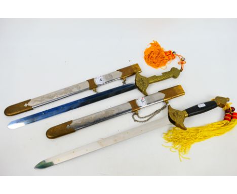 Two Chinese Shuang Jian style swords, 63 cm (l), the scabbards decorated with dragons chasing the flaming pearl and taijitu s