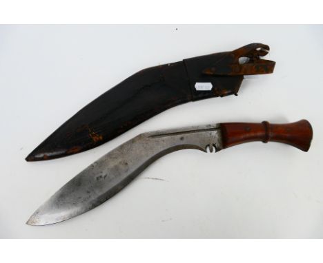 A vintage kukri with 30 cm (l) blade, wooden hilt and brass chapri, housed in leather scabbard. [W]

Note: This lot is not fo