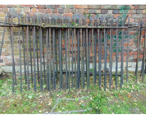 A run of four sections of 19th century iron railing with angular vertical bars beneath arrow head finials, varying in length,