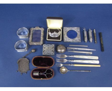 A mixed collection of silver and bijouterie to include two small silver applied frames, two silver napkin rings, silver Whisk