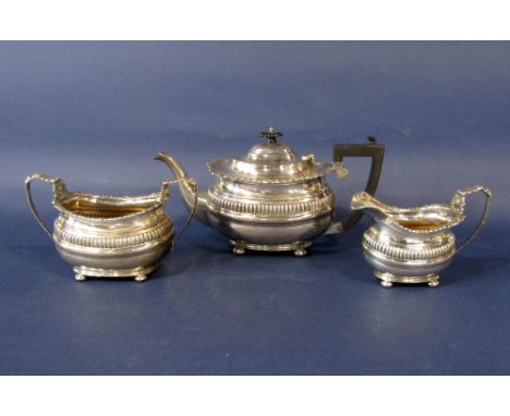 Early 20th century Georgian style three piece boat shaped tea service, with cast shell rims and part fluted bowls upon four b