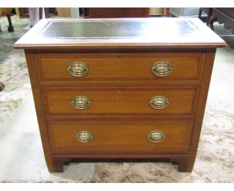 A small inlaid Edwardian mahogany chest of three long drawers crossbanded in satinwood, the top inset with leather raised on 