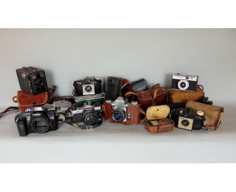 A box containing a collection of vintage cameras to include Canon and others, many in original cases