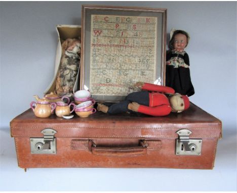 Vintage leather suitcase containing early 20th century Dutch doll with ceramic head, composition body in traditional clothing