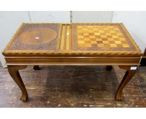 An Indian hardwood games/occasional table, the sliding and reversible top incorporating a chequer board and backgammon board,