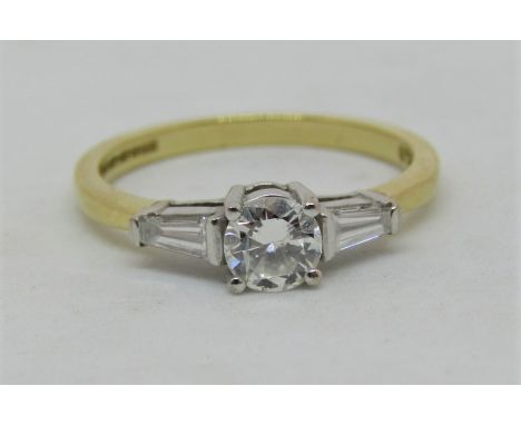 18ct three stone diamond ring, centre stone 0.25cts approx, flanked by a pair of baguette cut diamonds, size J/K, 2.3g