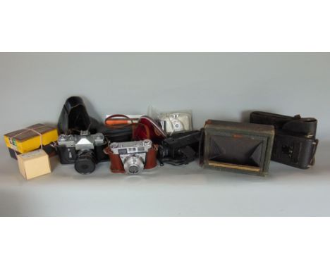 A box containing a collection of various vintage cameras, many in original cases