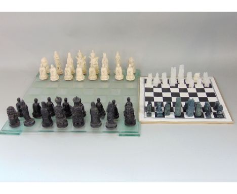 Two vintage chess sets, one a resin figural chess set with Chinese type figures, the other a carved soapstone example, both w