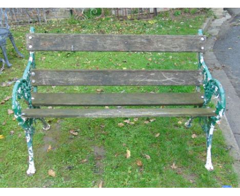 A two seat garden bench with timber lathes and decorative cast iron ends with fruiting vine pattern, 4ft long approx