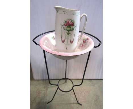A Victorian iron work washstand of tripod form enclosing a floral patterned basin