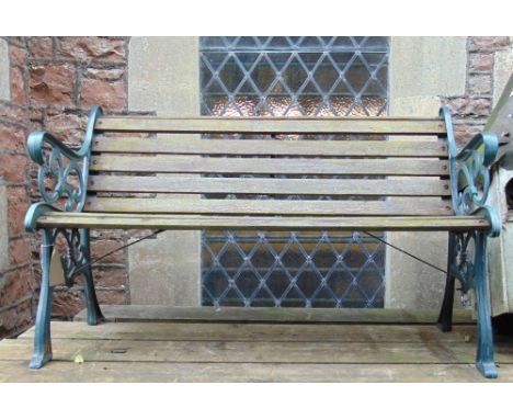 A two seat garden bench with timber lathes, and decorative cast iron end supports, 4ft long approx 