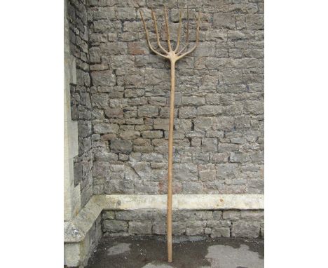 A traditional long handled wooden six pronged hay fork