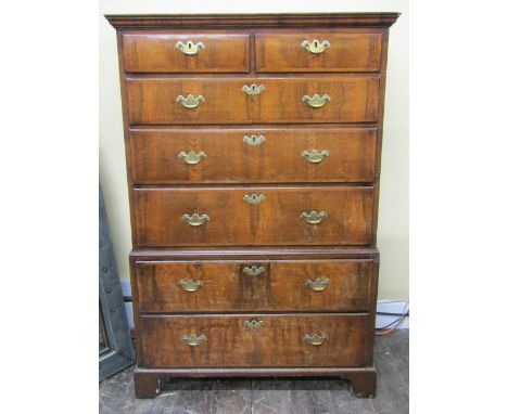 A Georgian walnut chest on chest of five long and two short drawers with crossbanded borders and brass fittings on bracket su