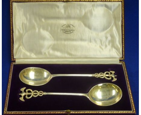 A fine pair of presentation hallmarked silver Serving Spoons, each with gilded bowl and a double winged urn style finial abov