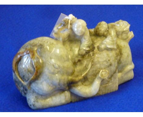 ADDED LOT    A Ming style carved jade Model of  two young boys playing upon an elephants back, his head turned to sinister, 1