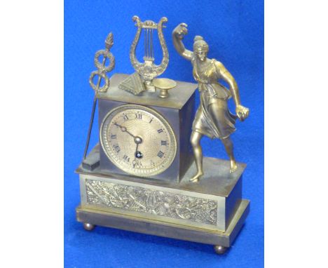 A French Empire period ormolu mounted figural Mantel Clock, the engraved dial with Roman numerals and surmounted by objects i