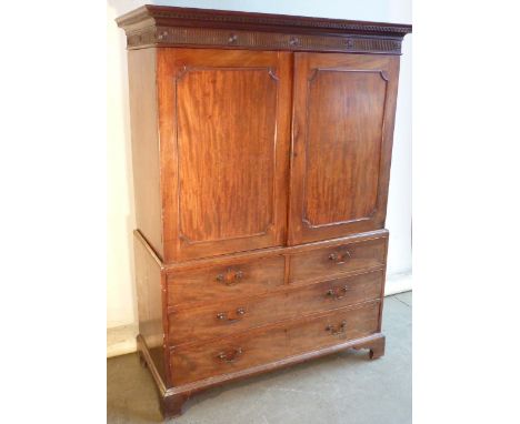 A late 18th Century mahogany Linen Press, the dentil cornice above a fluted frieze headed with roundel's, further over two pa