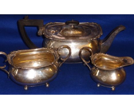 A heavy three piece hallmarked silver Tea Service comprising Tea Pot, two handled Sugar and Creamer, each engraved with armor