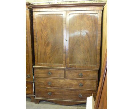 A George III mahogany Linen Press, outset cornice above two panelled doors enclosing slides and further over two half width a
