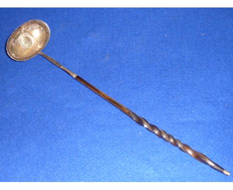 A Georgian white metal Toddy Ladle having spiral twist whale bone handle and the central bowl inset with a silver George II c