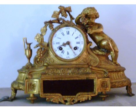 A 19th Century gilt metal eight day Mantel Clock, the cherubic figure with grapes and a glass above a white enamel dial with 