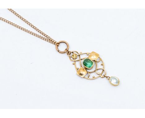 An Arts Nouveau 15ct gold green tourmaline pendant, comprising a central cushion cut tourmaline within an open border of scro