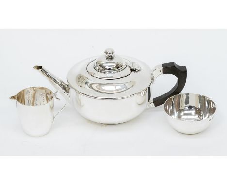 A George V plain circular silver matched three piece tea service comprising teapot, sugar bowl and milk jug, teapot with ebon