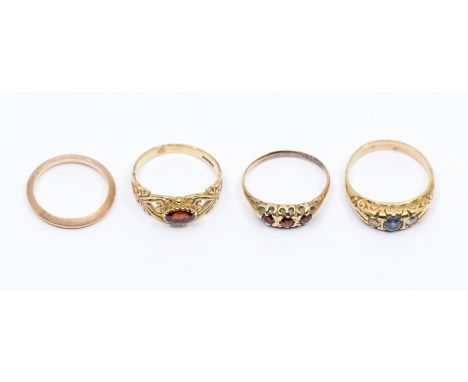 A collection of assorted 9ct gold rings, including two garnet set rings, a sapphire and white stone ring, and a 9ct gold face