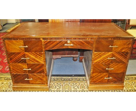 An early 20th Century Art Deco American walnut twin pedestal desk, the pedestals interconnected, originally used in the Full 
