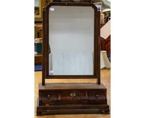 A George I burr walnut veneered toilet mirror, circa 1720, rectangular with canted corners, side supports with acorn finials,