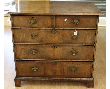A George I style walnut chest of drawers, comprising two short over three long drawers, feather banded and cross-banded edges
