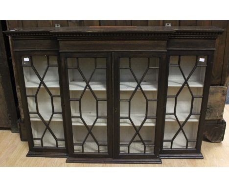 An early 20th Century mahogany breakfront glazed wall cabinet, in the Chippendale style, fitted with four glazed doors, enclo