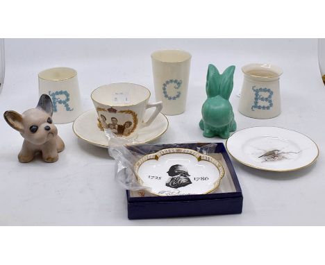 A Royal Worcester pin dish painted with bird on branch; three Goss beakers; a Sylvac dog and bunny; commemorative cup and sau