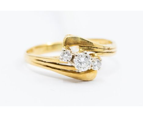 A diamond and 18ct gold three stone ring, comprising three claw set round brilliant cut diamonds, with a combined total diamo