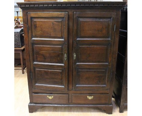 A mid to late 18th Century joined oak two door cupboard, each door with three raised and fielded panels, fitted with two draw