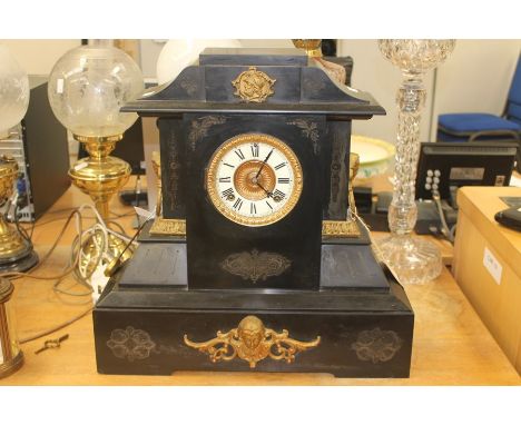 A late 19th Century American black slate mantel clock, having an eight day movement, white enamelled chapter ring, Roman nume