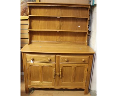 An Ercol elm dresser and rack, late 20th Century, the rack with two plate shelves, the base section with two drawers and two 