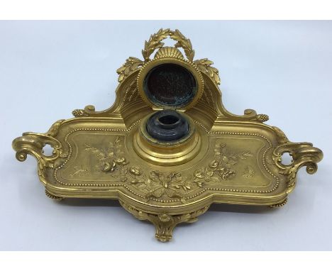 A 19th Century ormolu shape rectangular inkwell on stand, the raised back with central shell motif within laurel cartouche, t