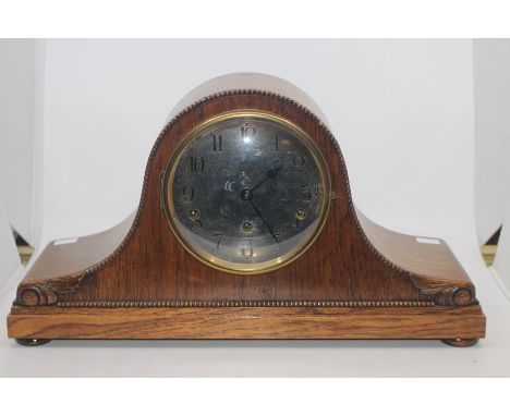 A mid-20th century oak cased mantel clock, silvered face with Arabic numerals.