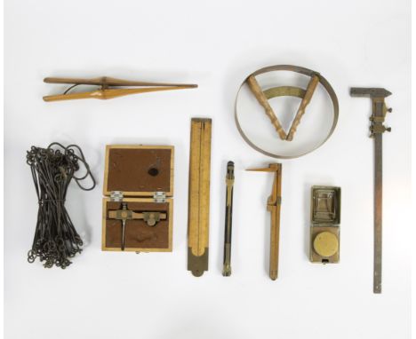 Collection of miscellaneous items including hat and shoe size gauge, glove pliers, surveyors' tools, notary paint bar melter,